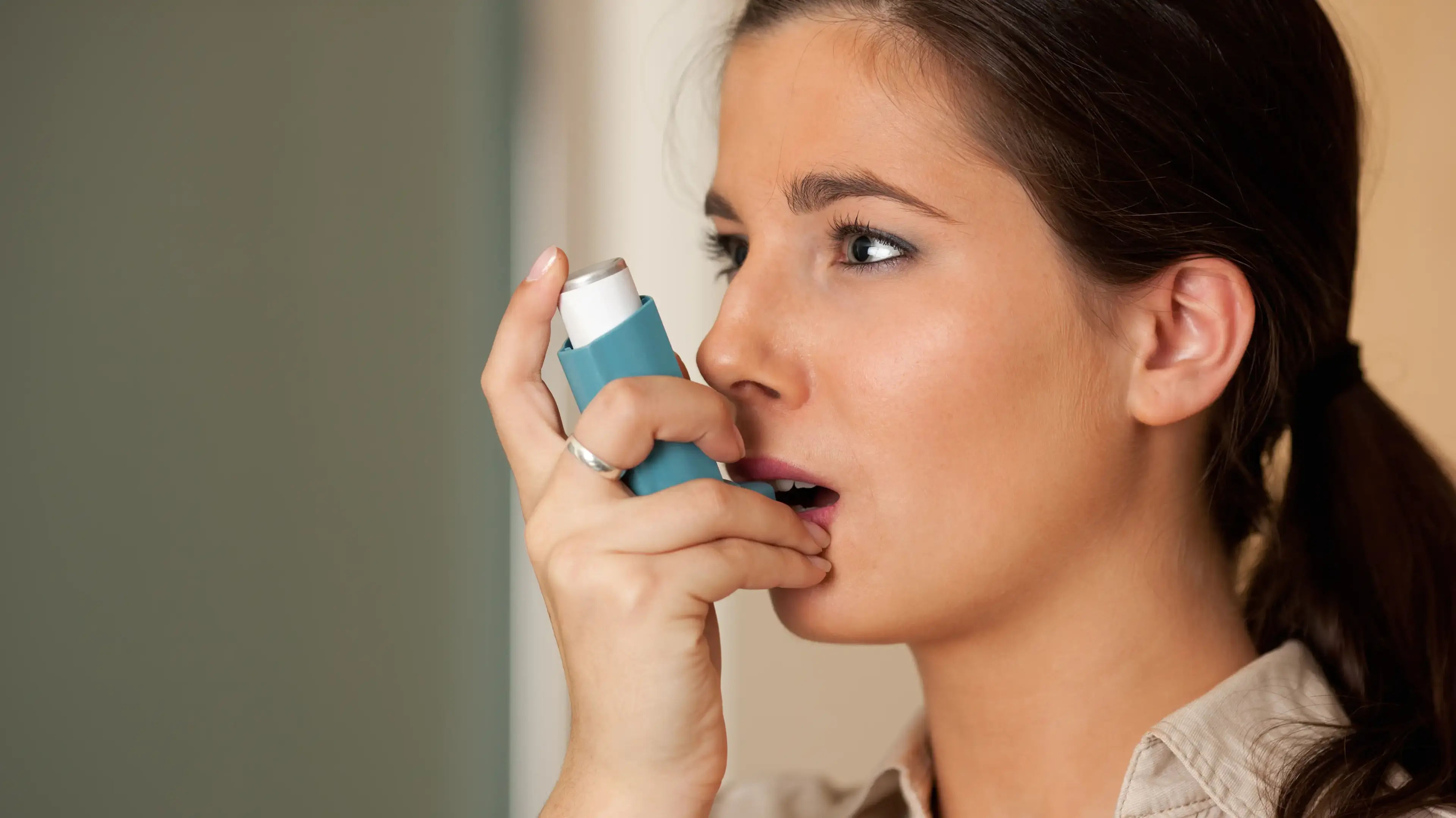 Adult using an inhaler to manage asthma
