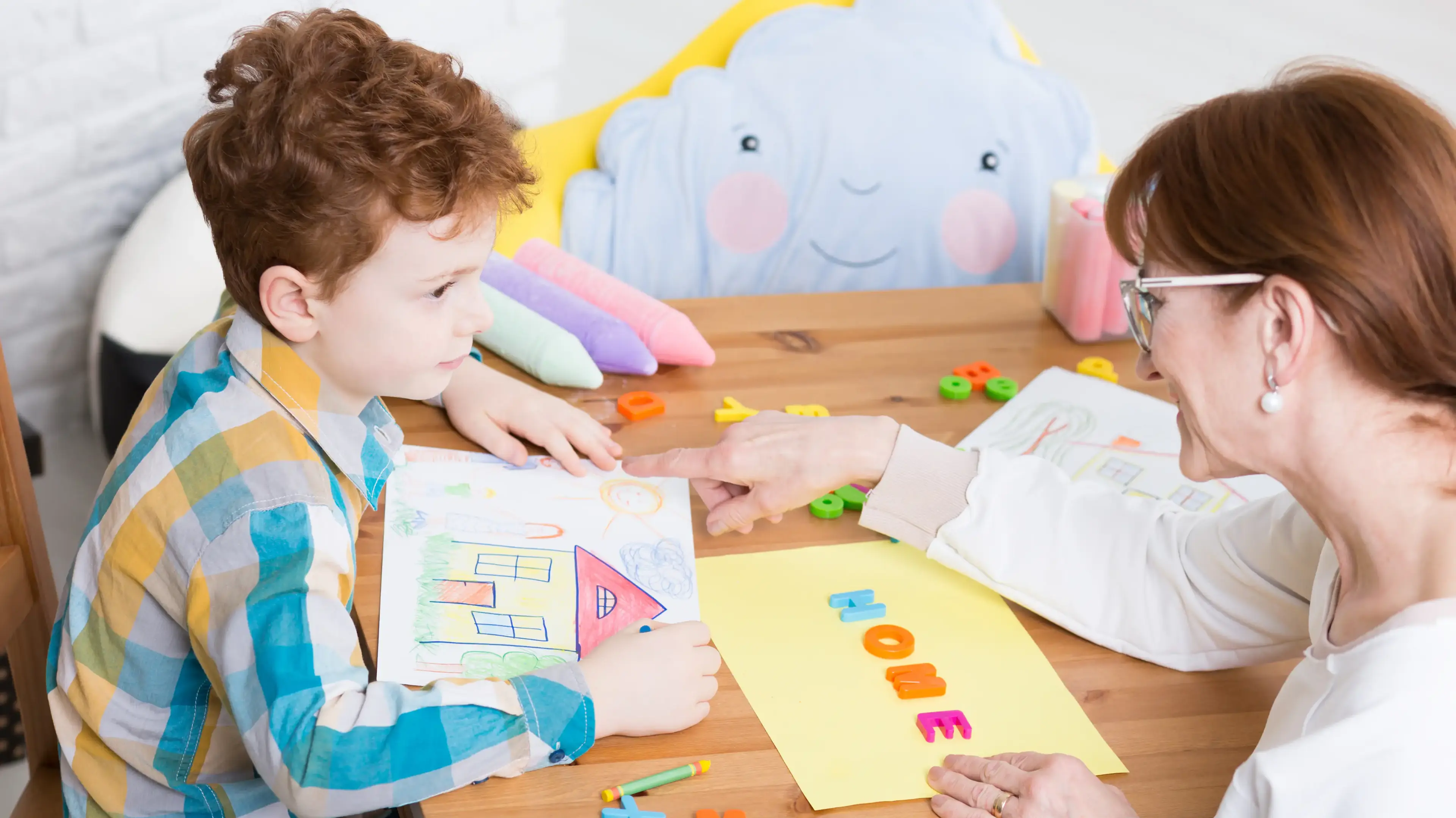 Child working with a caregiver on a drawing activity